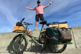 man stands beside pedego electric